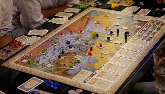 Personnes jouant à un jeu de société autour d'une table.